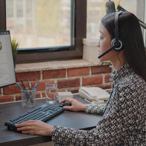 close-up-asian-woman-with-headphones-talking-phone-call-people-customer-service-consultant-using-headset-microphone-working-call-center-computer-support-chat (1)