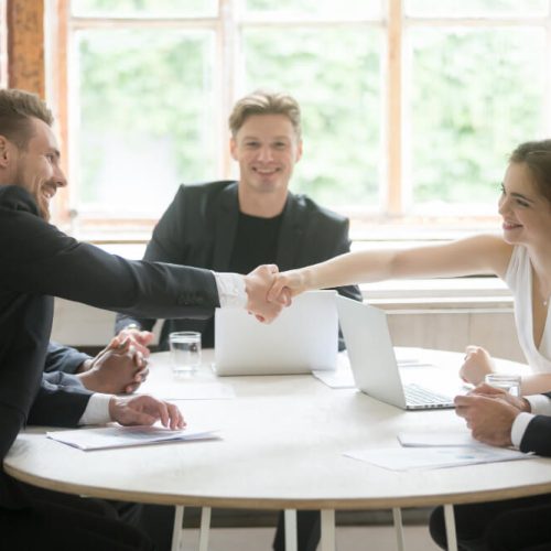 male-executive-shaking-hands-with-female-coworker-teamwork-introduction (1)